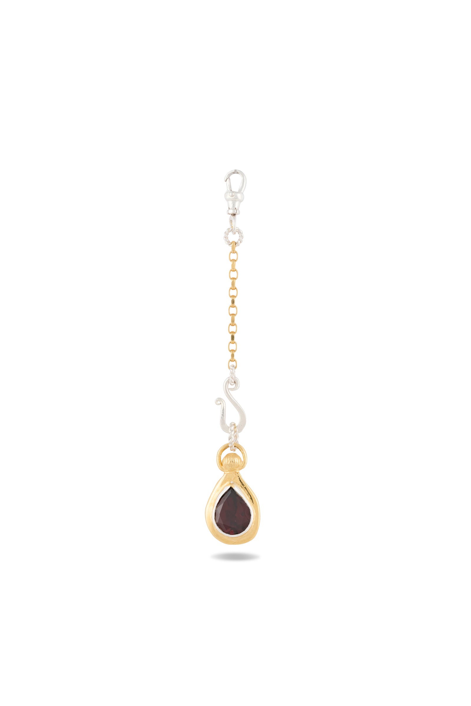 The “My Blood, Your Blood, Our Blood Charm” earring by Jessica de Lotz Jewellery features gold and silver chain accents with a teardrop-shaped red gemstone set in gold, topped with a decorative gold cap and finished with a small silver hook. Displayed against a plain white background, this unique piece is inspired by Practical Magic charms and beautifully captures the essence of sisterhood jewelry.