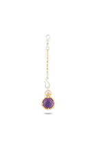 Introducing the ’There’s A Little Witch In All Of Us’ Charm by Jessica de Lotz Jewellery: a striking keychain featuring a petite cat charm perched atop a lustrous amethyst cabochon, set within a gleaming gold bezel. The piece is elegantly suspended from a gold chain and secured with a silver lobster clasp. Reminiscent of a modern-day chatelaine, this enchanting accessory channels the mystique of Practical Magic charms. Photographed against a white background.