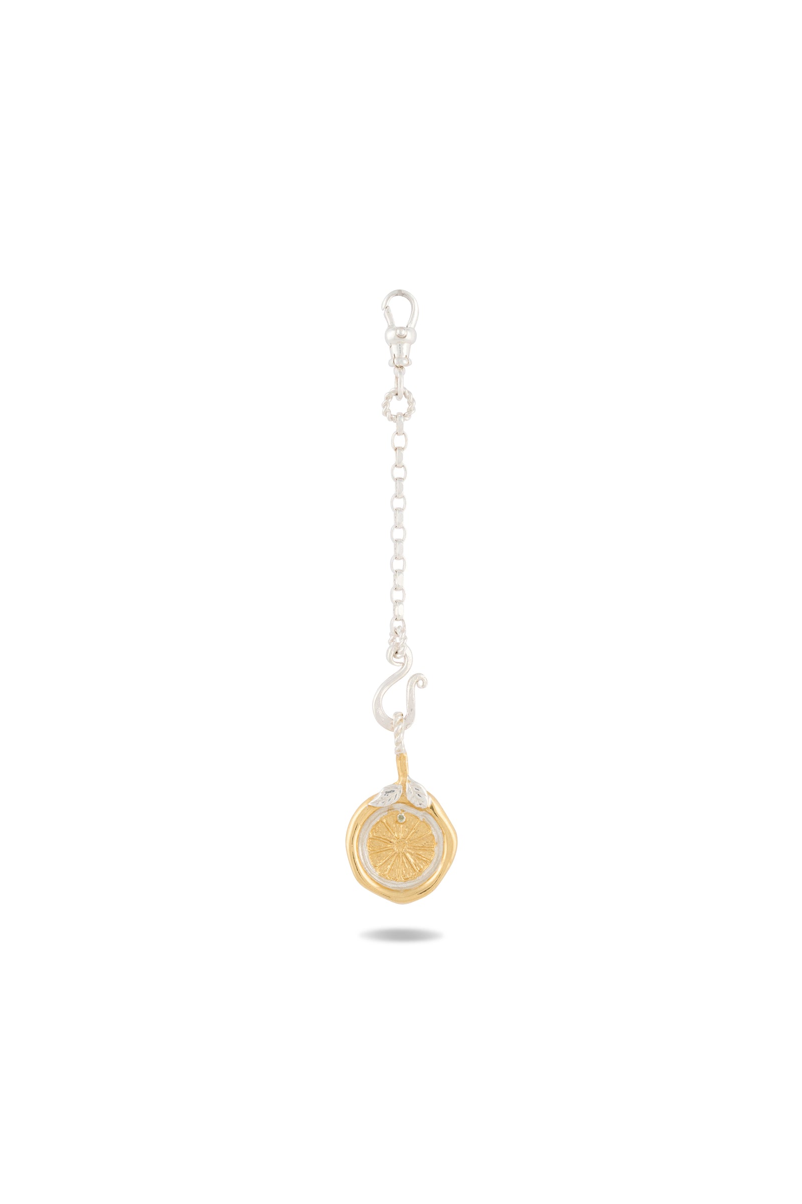 The Midnight Margarita Lime Charm by Jessica de Lotz Jewellery features a short silver chain, a clasp, and a gold coin-like charm adorned with a raised starburst pattern at its center—evoking the style of modern chatelaine accessories or Practical Magic-inspired charms. It is showcased against a plain white background with a subtle shadow beneath.