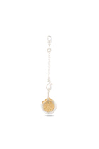 The Midnight Margarita Lime Charm by Jessica de Lotz Jewellery—a silver keychain featuring a circular pendant resembling a dried lemon slice encased in a delicate metal frame, with a small chain and clasp—rests centered on a plain white background with a faint shadow beneath, evoking the enchanting appeal of Practical Magic charms for the modern-day chatelaine.