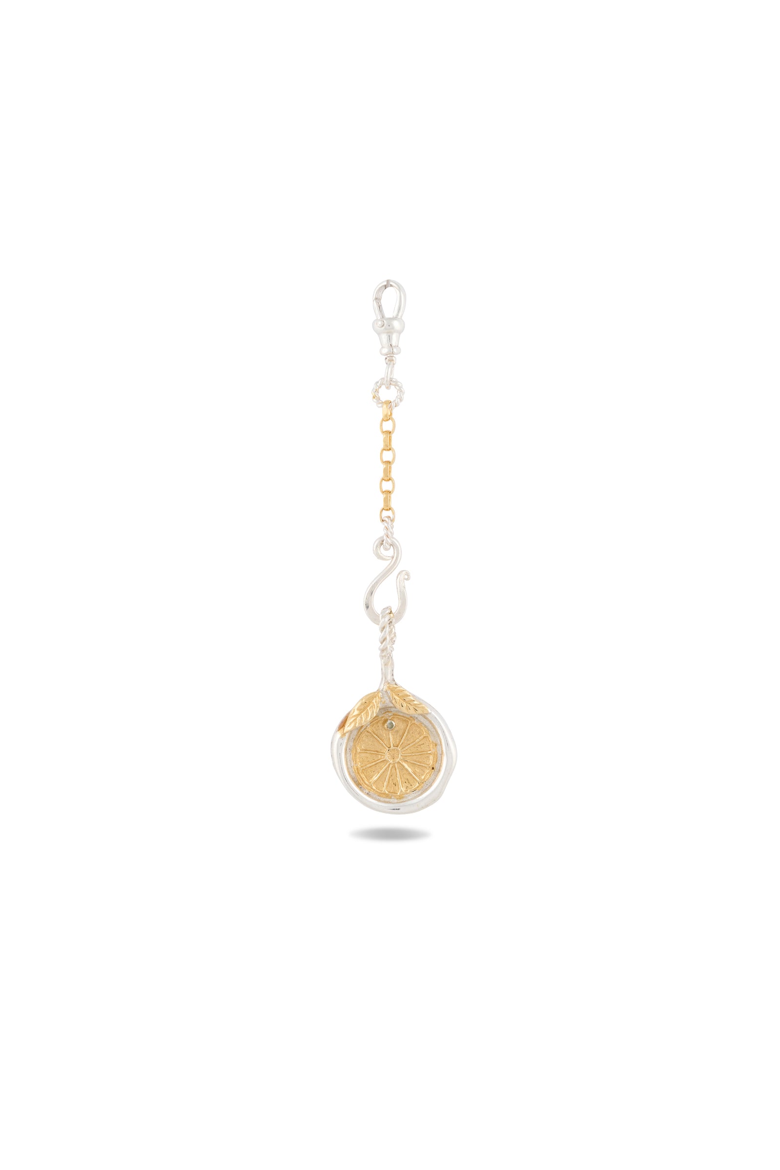 A “Midnight Margarita Lime Charm” by Jessica de Lotz Jewellery, featuring a circular gold medallion with a compass rose design, is attached to a small silver chain and clasp—reminiscent of a modern-day chatelaine—and displayed on a white background with a soft shadow beneath.