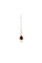 Introducing the My Blood, Your Blood, Our Blood Charm by Jessica de Lotz Jewellery: a striking silver earring featuring a dangling teardrop-shaped deep red gemstone nestled in a silver setting. The decorative hook and chain are adorned with delicate silver accents, evoking the essence of sisterhood and Practical Magic-inspired charms. This unique piece stands out beautifully against the plain white background.