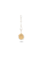 A keychain featuring the Jessica de Lotz Jewellery Midnight Margarita Lime Charm—with a gold, round lime slice—hangs from a silver chain and clasp. Set against a white background, the keychain casts a faint shadow below it. The lime slice is intricately detailed with visible segments and rind, making it an enchanting accessory for any modern-day chatelaine who loves Practical Magic charms with a hint of kitchen witchcraft flair.