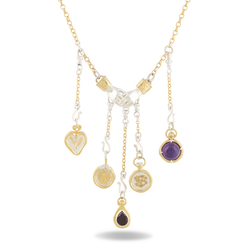 The Practical Magic Chatelaine Hand Necklace (Charm & Chain Bundle) by Jessica de Lotz Jewellery showcases five dangling charms—a heart, coin, flower, gemstone, and teardrop—each detailed with gold accents. The charms are suspended from silver hands joined at the center, with a shadow beneath suggesting the necklace is displayed flat.