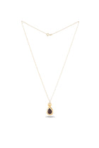 A delicate gold chain necklace from Jessica de Lotz Jewellery showcases the “My Blood, Your Blood, Our Blood Charm,” a small teardrop-shaped pendant with a dark, glossy center encased in gold. Reminiscent of sisterhood jewelry from Practical Magic charms, the necklace is displayed against a plain white background to highlight its simple elegance.