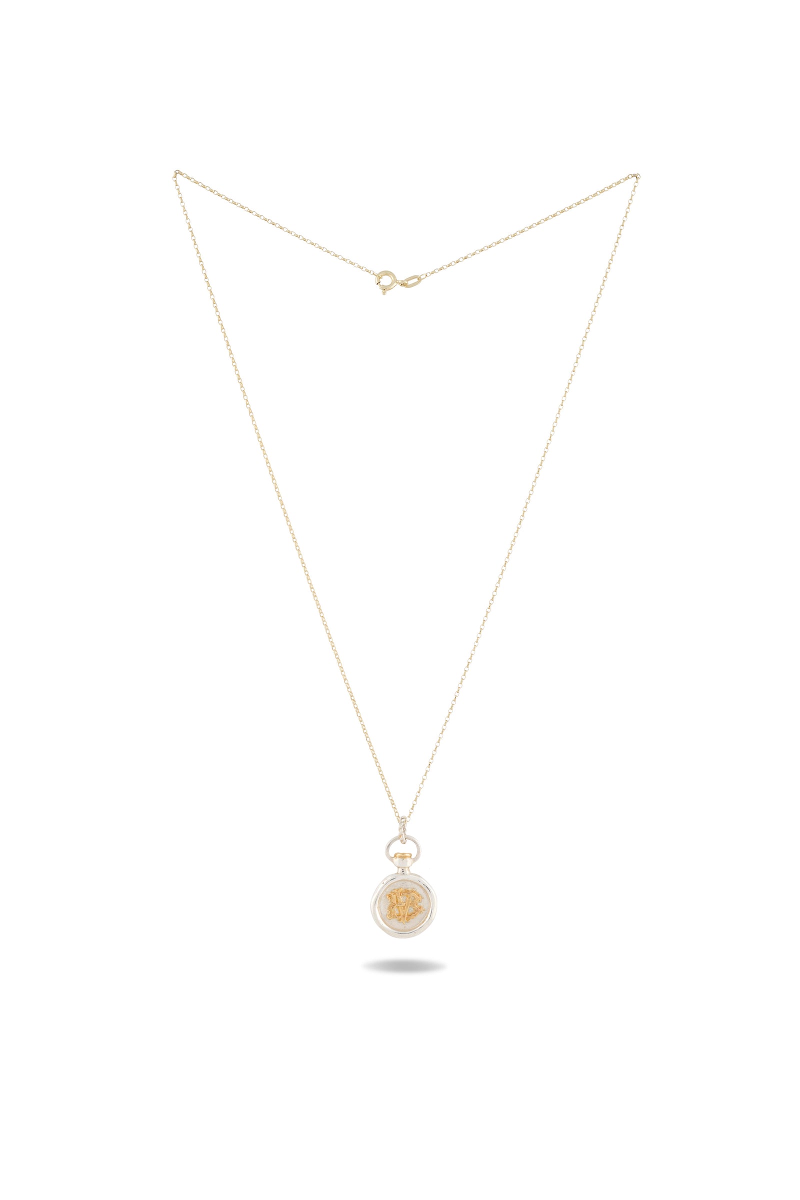 A delicate gold necklace by Jessica de Lotz Jewellery, featuring the Verbena Botanical Apothecary Bottle Charm—a thin chain with a circular pendant showcasing an intricate botanical wax-seal design at its center, photographed against a white background.