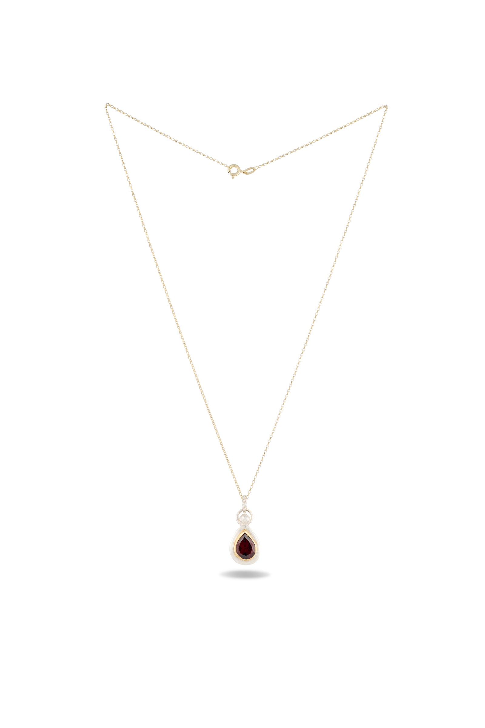 Introducing the Our Blood Pendant by Jessica de Lotz Jewellery—a delicate gold chain necklace showcasing a teardrop-shaped deep red gemstone, elegantly set in a simple gold bezel. Arranged in a triangle on a white background, this timeless piece captures the enchanting allure of Practical Magic charms.