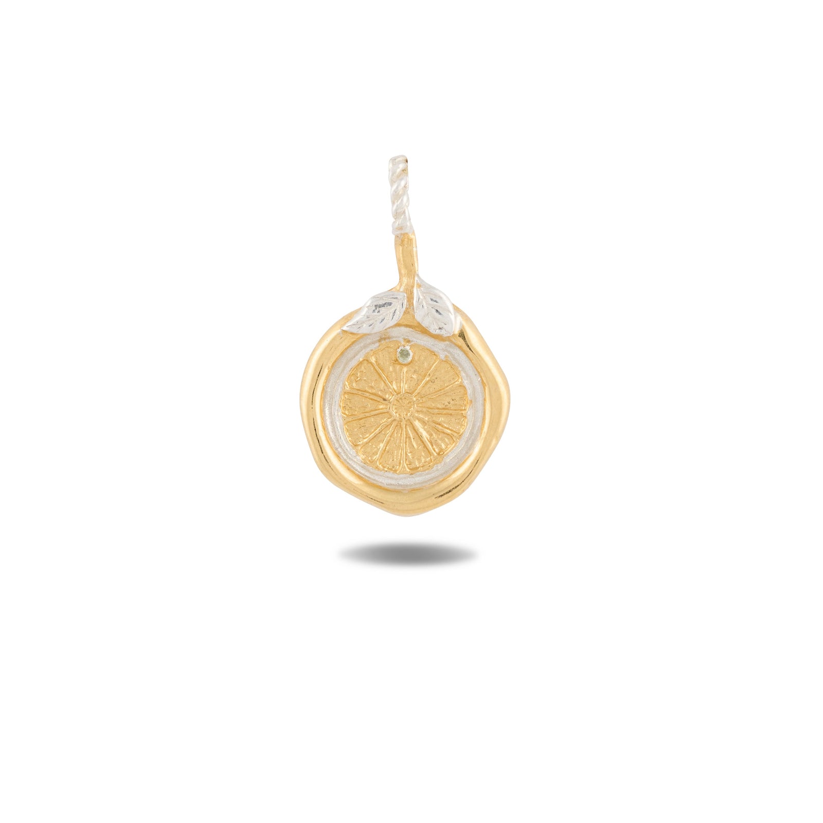 Introducing the Midnight Margarita Charm by Jessica de Lotz Jewellery: a gold and silver pendant artfully shaped like a lemon slice, featuring intricate textured details. Reminiscent of Practical Magic charms, this piece is adorned with two delicate silver leaves at the top and includes a loop for easy attachment to your favorite chain. Photographed against a white background, the pendant casts a subtle shadow, highlighting its unique craftsmanship.