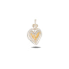 Certainly! Here’s a rewritten sentence using the provided product data: The Amas Veritas Charm by Jessica de Lotz Jewellery features a silver heart-shaped pendant with a twisted loop at the top, capturing an enchanting aesthetic. At its center lies an intricate gold fern design, evoking the whimsical allure of Practical Magic charms. The pendant is showcased against a white background with a faint shadow below.