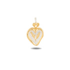 The Amas Veritas Charm by Jessica de Lotz Jewellery is a heart-shaped pendant in gold and silver, featuring a loop at the top for hanging. Its center showcases a textured, intricate design inspired by Practical Magic charms, and the pendant casts a subtle shadow on a white background.