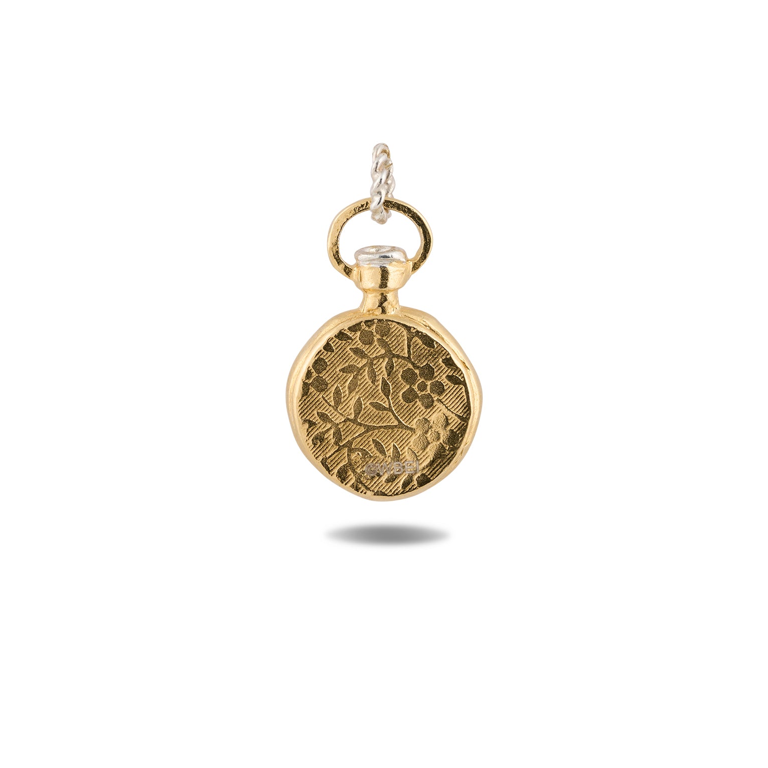 A closed, round Verbenca Botanical Charm Bottle Top by Jessica de Lotz Jewellery, adorned with an engraved floral pattern and suspended from a silver twisted loop, evokes the enchanting allure of Practical Magic. The slightly textured charm casts a soft shadow on a white background, with no visible clock face or hands.