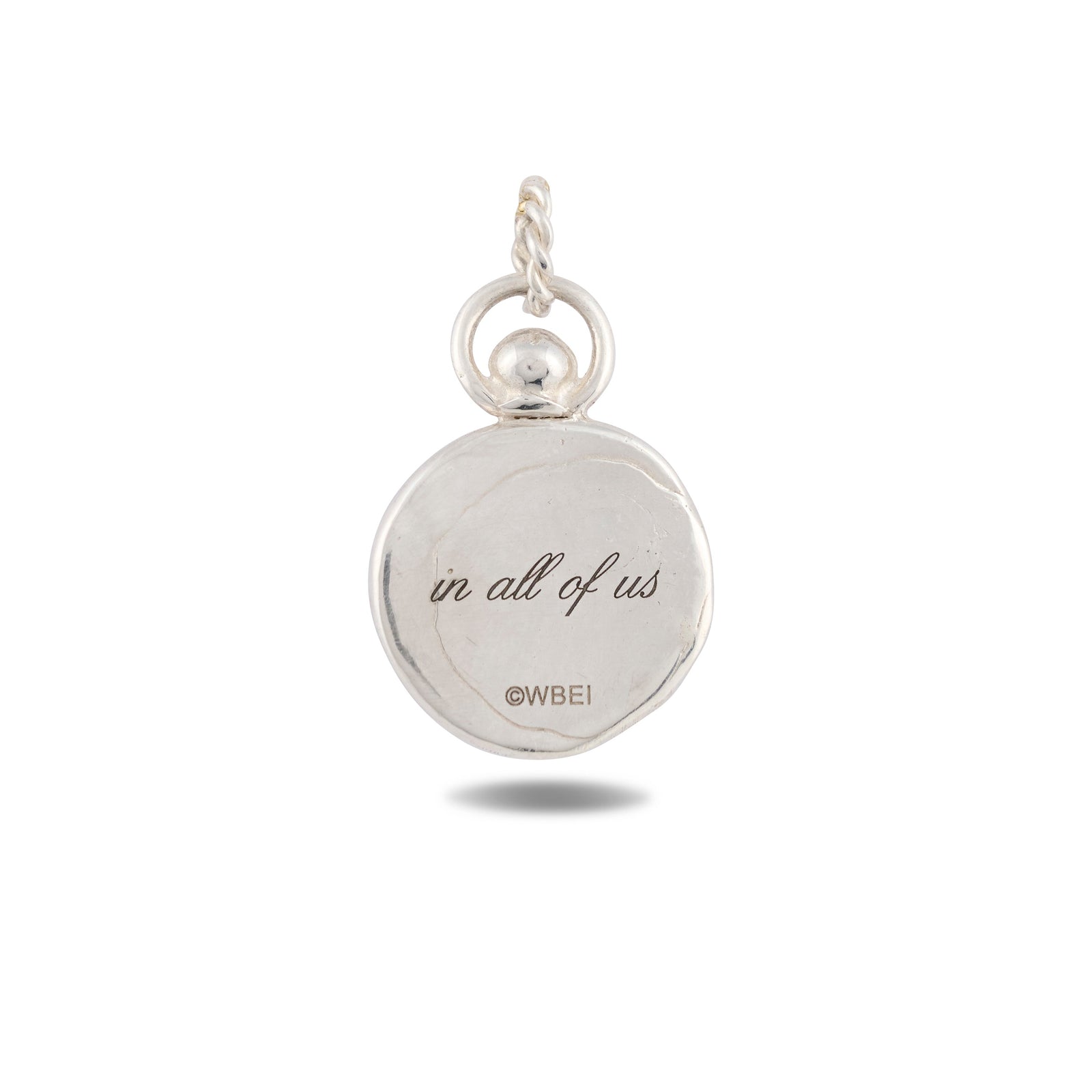 A circular silver charm from Jessica de Lotz Jewellery, named the “There’s A Little Witch In All Of Us Charm,” features a small loop at the top, evoking vintage wax seal designs. Engraved in cursive are the words there’s a little witch in all of us, with ©WBEI in a simple font beneath—a graceful homage to the magical world of Practical Magic 2. Presented against a clean white background.