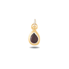 Introducing the “My Blood, Your Blood, Our Blood Charm ~ Limited Edition” by Jessica de Lotz Jewellery—a teardrop-shaped gold pendant featuring a deep red garnet gemstone at its center. The pendant’s textured gold border evokes the look of antique wax-seal blood charms, and it is finished with a delicate gold loop for attaching to your favorite necklace. Shown against a plain white background.