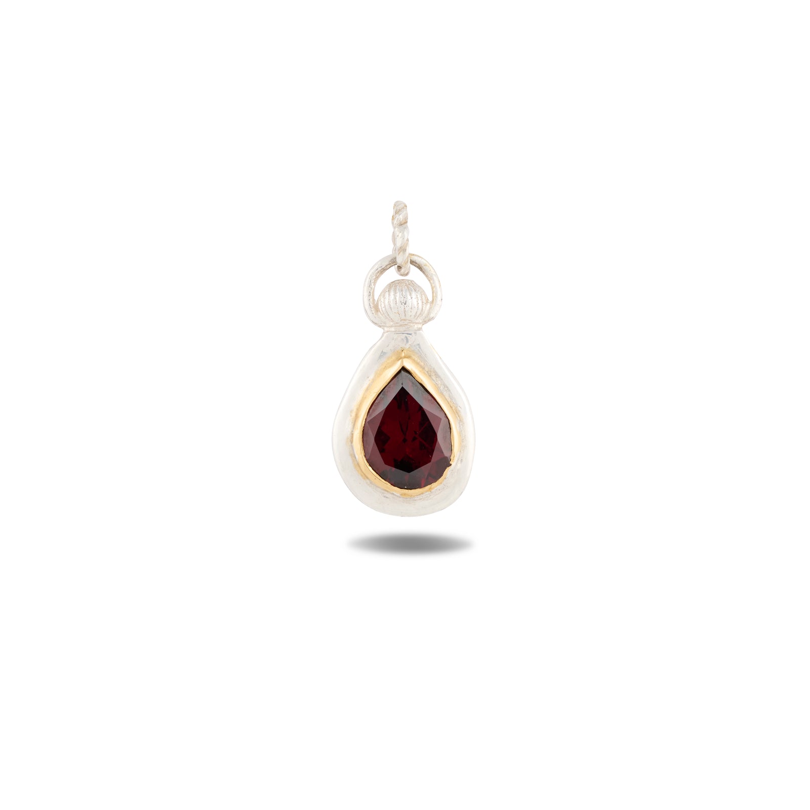Certainly! Here is a rewritten version of the sentence using the given product data: The Our Blood Pendant by Jessica de Lotz Jewellery features a teardrop-shaped, deep red gemstone set in a gold bezel and framed by a silver border—evoking the enchanting charms often found in Jessica de Lotz’s creations. The pendant includes a small, textured silver loop at the top for easy attachment to your favorite chain. The faceted gemstone casts a subtle shadow below, imparting an air of mysterious allure.