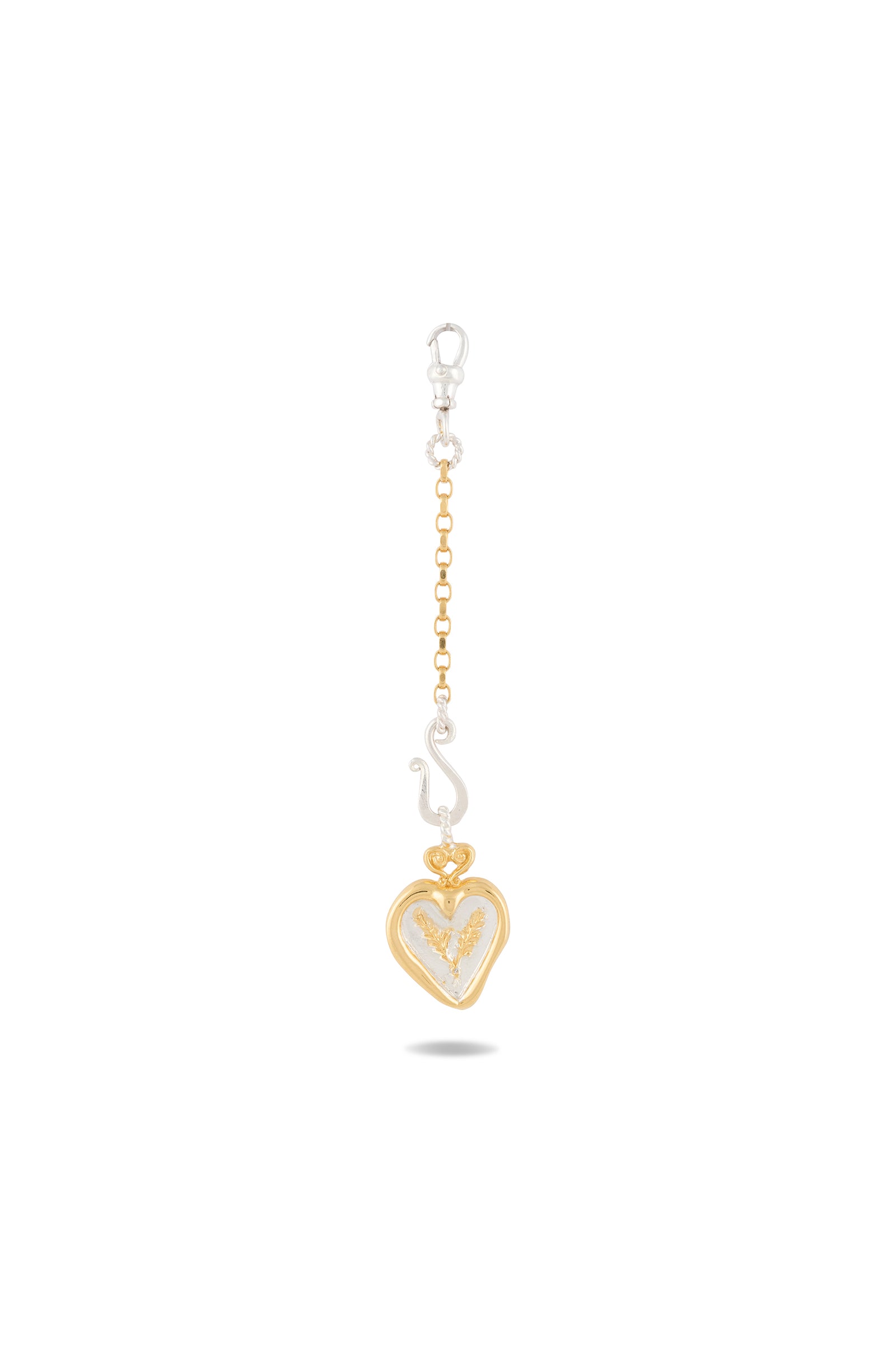 A gold and silver keychain—Jessica de Lotz Jewellery’s Amas Veritas Spell Charm—features a gold heart-shaped pendant with a delicate white feather motif, inspired by sisterhood charms in Practical Magic 2. The chain alternates between gold and silver links with a silver clasp at the top, casting a subtle shadow beneath it on a white background.