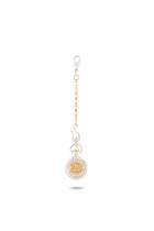 The Verbena Botanical Apothecary Bottle Charm by Jessica de Lotz Jewellery is a mixed metal keychain featuring a circular gold and silver pendant with a raised lion motif reminiscent of a botanical wax-seal charm, elegantly suspended from a chain with a lobster clasp and photographed against a plain white background.