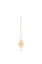 The Amas Veritas Spell Charm by Jessica de Lotz Jewellery showcases a gold chain with a lobster clasp, a silver S charm, and a gold heart-shaped pendant featuring a textured white inner heart. Reminiscent of modern chatelaine designs, this minimalist accessory embodies timeless elegance through its clean lines and subtle detailing, displayed against a white background with a gentle shadow below.