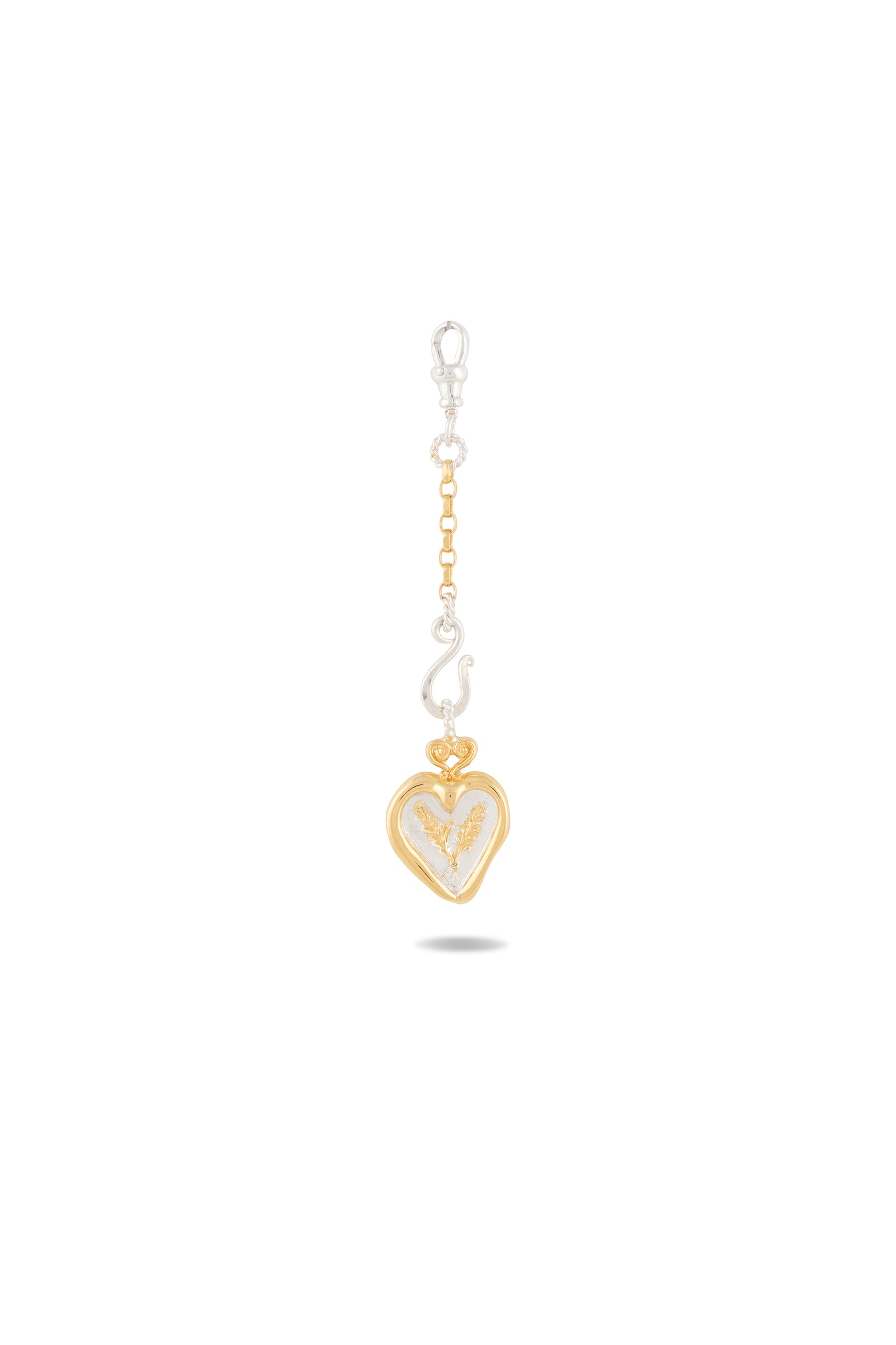An enchanting keychain from Jessica de Lotz Jewellery, the Amas Veritas Spell Charm features a heart-shaped pendant with a gold outline and intricate silver interior, inspired by sisterhood charms and echoing the magical style of Practical Magic 2. The chain alternates between gold and silver links and is finished with a silver clasp at the top, while a subtle shadow nestles beneath the pendant.