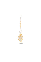 A modern chatelaine, the Amas Veritas Spell Charm by Jessica de Lotz Jewellery features a gold chain with a lobster clasp, ending in a gold heart pendant outlined in white and adorned with an angel wing motif, all set against a plain white background. Inspired by the spirit of sisterhood charms, it’s perfect for fans eagerly awaiting Practical Magic 2.