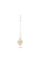 A silver chain keychain with a lobster clasp features Jessica de Lotz Jewellery’s Amas Veritas Spell Charm—a heart-shaped silver pendant reminiscent of a modern chatelaine. Nestled inside the heart is a smaller, textured gold heart, symbolizing timeless sisterhood. The item is centered on a white background with a faint shadow beneath it.