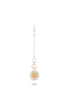 A silver chain keychain from Jessica de Lotz Jewellery, named the Verbena Botanical Apothecary Bottle Charm. It features a round pendant with a raised gold Medusa head at its center, set within a clear, oval-shaped frame inspired by botanical wax-seal charm designs. The chain is finished with a lobster clasp for easy attachment. Displayed against a plain white background.