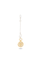 A gold, round “Verbena Botanical Apothecary Bottle Charm” by Jessica de Lotz Jewellery hangs from a short silver chain with a lobster clasp at the top. Featuring an engraved design inspired by botanical wax-seal charm styles, this unique piece evokes the allure of sisterhood jewelry and Practical Magic charms. Set against a pure white background, the charm casts a faint shadow below.
