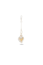 The Amas Veritas Spell Charm by Jessica de Lotz Jewellery is a silver keychain with a lobster clasp, showcasing a heart-shaped pendant inspired by modern chatelaine designs. Inside the clear-encased pendant lies an intricate gold feather or leaf motif, elegantly symbolizing sisterhood. Photographed against a plain white background with a delicate shadow beneath, this enchanting accessory echoes the subtle allure of Practical Magic 2.