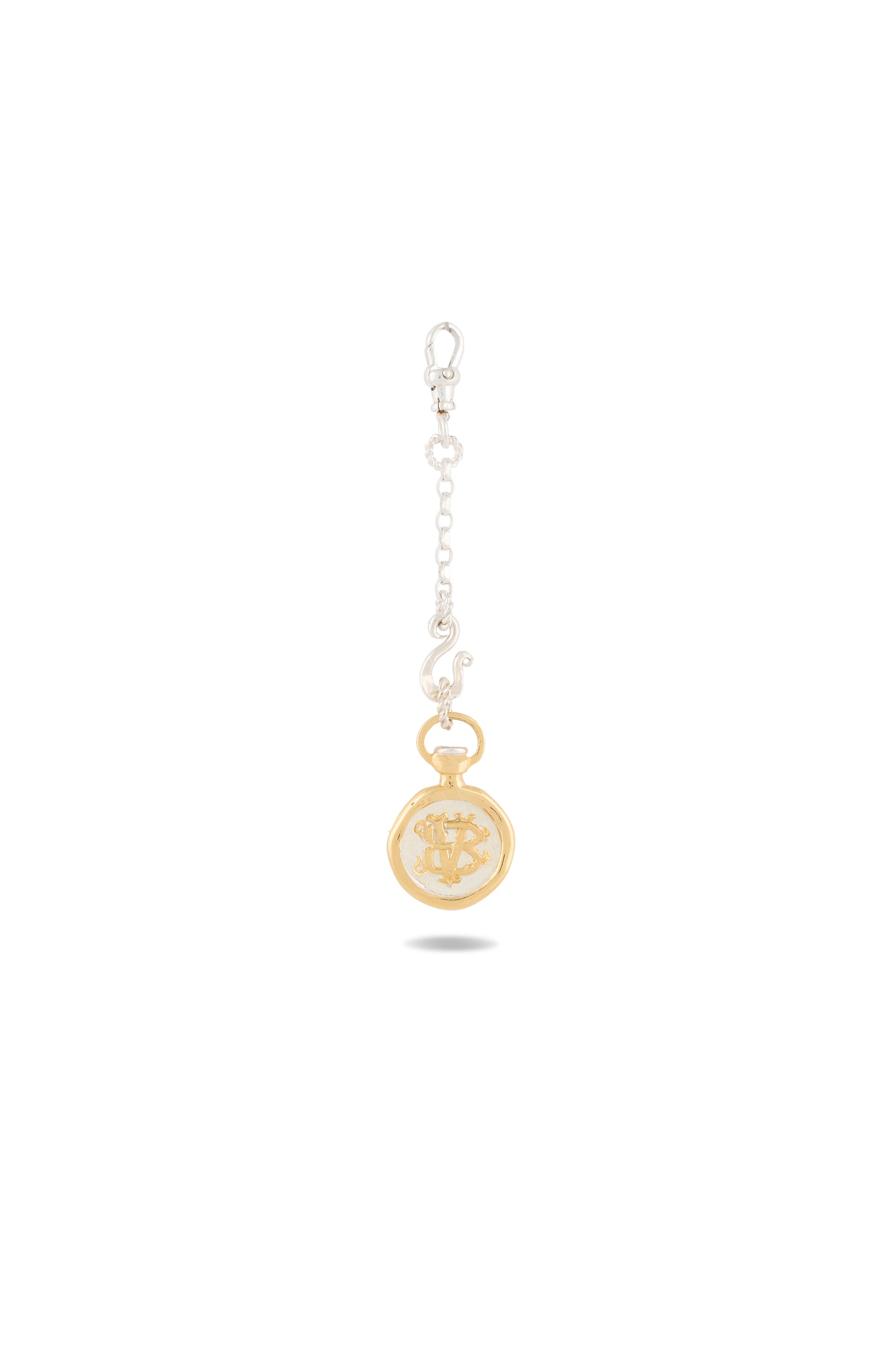 A gold and silver keychain from Jessica de Lotz Jewellery, featuring the Verbena Botanical Apothecary Bottle Charm—a round, gold-tone medallion suspended from a short silver chain. The intricately detailed medallion evokes the enchanting spirit of Practical Magic charms and sisterhood jewelry. A sturdy clasp at the top ensures secure attachment. Photographed against a plain white background.