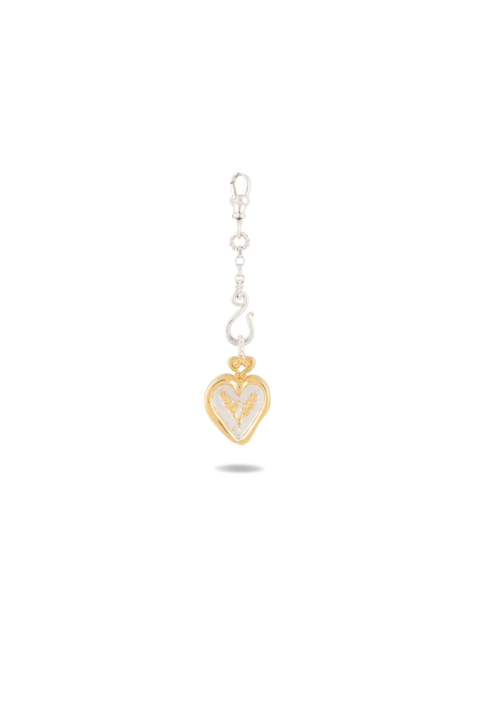 Introducing the Amas Veritas Spell Charm by Jessica de Lotz Jewellery—a graceful piece showcasing a gold-outlined heart with a silver angel nestled inside, suspended from a silver clasp and hook. Evoking the timeless elegance of modern chatelaine style, this charm captures the essence of sisterhood. Presented against a plain white background with a delicate shadow below, its exquisite design is truly highlighted.