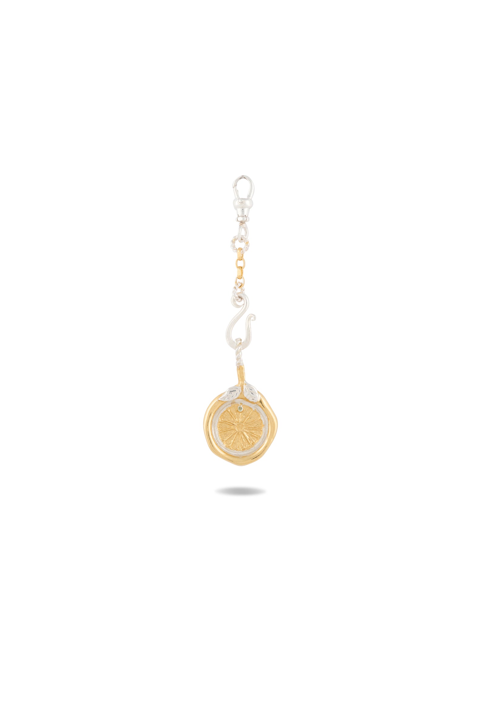 The Midnight Margarita Lime Charm by Jessica de Lotz Jewellery—a gold keychain adorned with a round lime slice charm featuring detailed segments, attached to a silver clasp and chain—is centered on a white background with a faint shadow below, making it an ideal accessory for the modern-day chatelaine or as part of your Practical Magic charms collection.