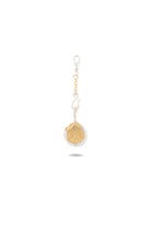 Introducing the Midnight Margarita Lime Charm by Jessica de Lotz Jewellery—a stylish keychain featuring a metallic hook, a silver and gold chain, and a circular pendant that evokes the look of a sliced citrus fruit. The pendant’s gold interior is etched with segment lines, bordered by a sleek silver rim—an elegant interpretation of modern-day chatelaine style with the whimsical allure of Practical Magic charms. Against a white background, the piece casts a delicate shadow.