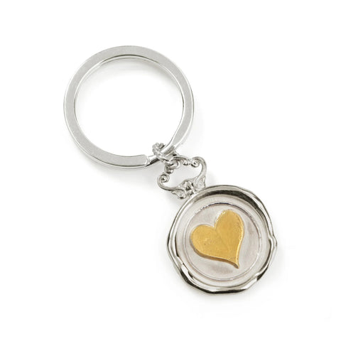 The JdL Jewellery Wax Seal Keyring features a silver keyring with a round pendant, showcasing a raised gold heart at the center and a decorative top, all elegantly set against a plain white background.