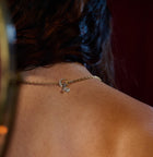 A close-up of a person’s upper back and neck highlights the Practical Magic Chatelaine Hand Necklace by Jessica de Lotz Jewellery, showcasing its elegant and intricate toggle clasp. The necklace rests delicately against the skin, drawing attention to the detailed clasp design. Partially visible on the left side is the person’s wavy, dark hair, adding to the allure of this piece from Jessica de Lotz Jewellery’s Practical Magic collection.